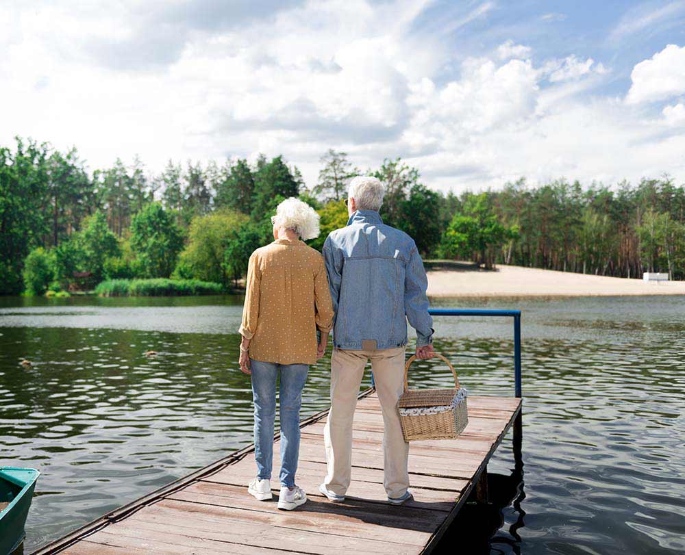 Stylish elderly wife and husband having romantic date near river